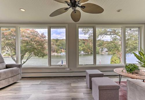 a living room with windows with a view of the water at Lake Hopatcong Family Home with Boat Slip and Dock in Hopatcong