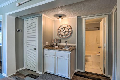 a bathroom with a sink and a clock on the wall at Relax by Pool and Walk to Beach Hilton Head Condo! in Hilton Head Island