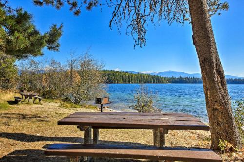 a wooden picnic table sitting next to a lake at Quaint Priest Lake Cabin with Patio Less Than 1 Mi to Lake! in Vans Corner