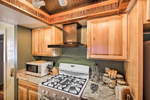 a kitchen with a stove and a microwave at Quaint Priest Lake Cabin with Patio Less Than 1 Mi to Lake! in Vans Corner