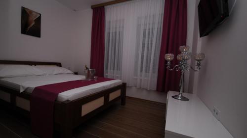 a bedroom with a bed and a window at Hotel Rafaelo in Bosanska Dubica