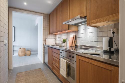 a kitchen with wooden cabinets and a stove top oven at Sands Hotell in Sandhamn