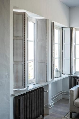 a living room with windows and a radiator at Sands Hotell in Sandhamn