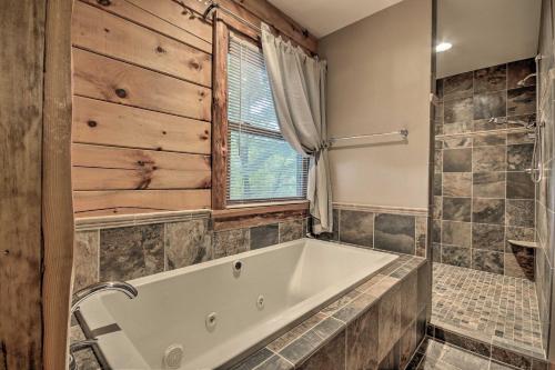 a bathroom with a large tub and a window at Pet-Friendly Raystown Lakefront Cabin with BBQ Grill in Hesston