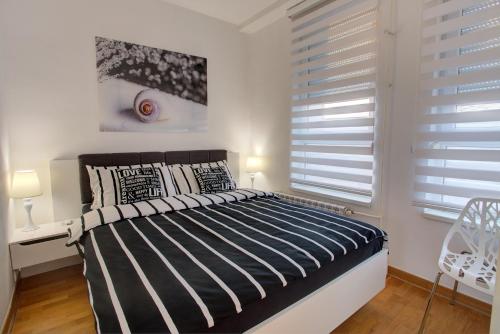 a bedroom with a bed with black and white pillows at Belville Luxury Apartment in Belgrade