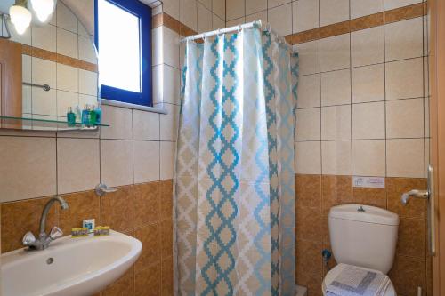 a bathroom with a shower curtain and a sink at Sfakian Horizon in Khóra Sfakíon