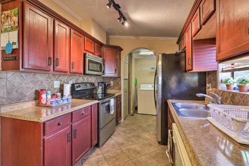 a kitchen with wooden cabinets and stainless steel appliances at 3 Mi to Lake Powell Page Home with Patio and BBQ in Page