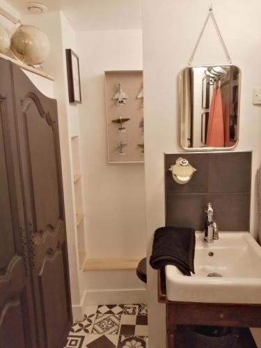 une salle de bain avec un lavabo et un miroir dans l'établissement Les Petites Suites Dieppoises - Le Petit Prince A Dit, à Dieppe