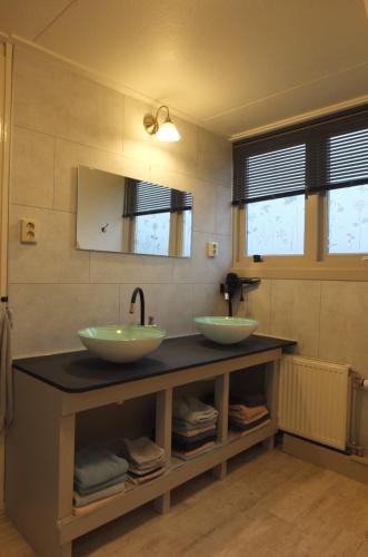 two sinks on a counter in a bathroom at B&B Ferdivedaasje in Dokkum