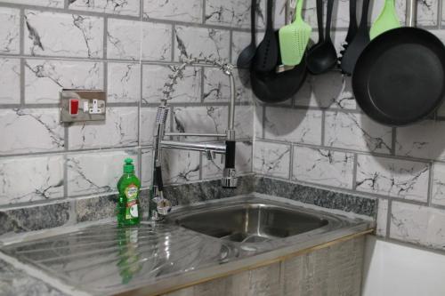 a kitchen sink with a green bottle next to it at Amazing Grace Hostel and International Serviced Apartments in Ibadan