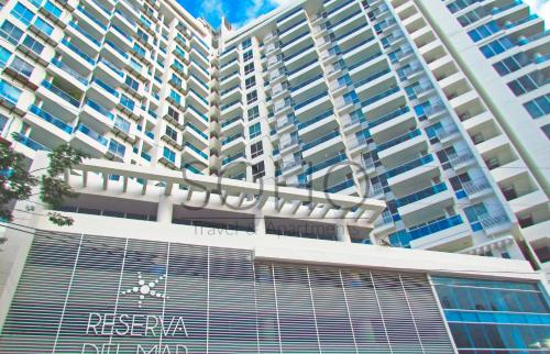 a tall building with a sign on the front of it at Apartasuites Reserva del Mar - Frente al Mar by SOHO in Santa Marta