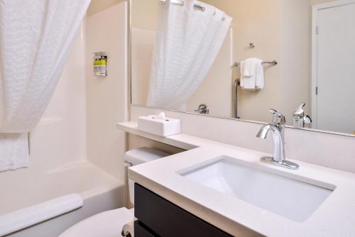 a bathroom with a sink and a toilet and a mirror at Candlewood Suites Sierra Vista, an IHG Hotel in Sierra Vista