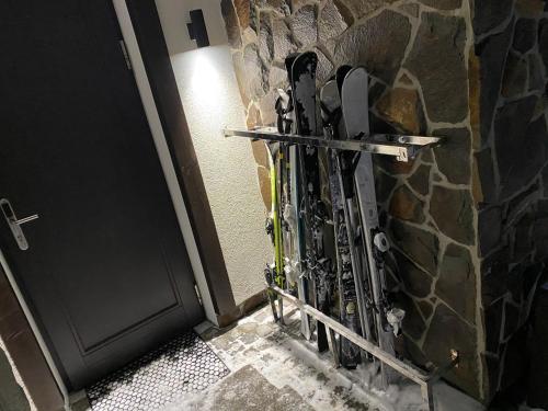 a group of skis leaning against a stone wall at PANORAMA Chalet MOUNTAIN RESIDENCE in Bukovel