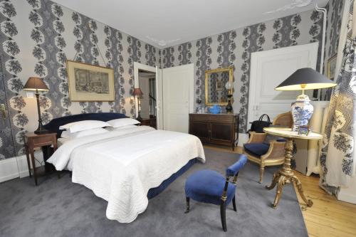 a bedroom with a bed and a table and chairs at La Maison D'hôtes du Parc in Ronchamp