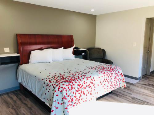 a hotel room with a bed with a red flowered blanket at BEL AIR MOTEL in Wood River