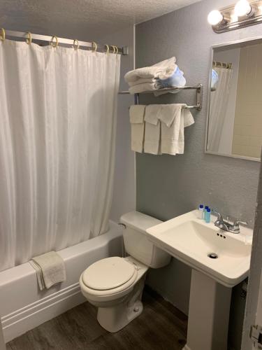 uma casa de banho com um WC branco e um lavatório. em City Center Motel em Las Vegas