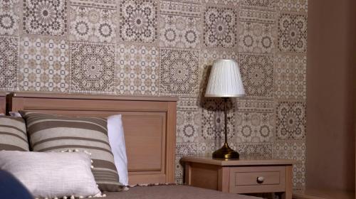 a bedroom with a bed and a table with a lamp at House of Garden in Dhráganon