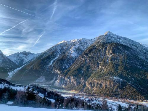 a mountain covered in snow with a river in front of it at Das Haus Kunz in Imsterberg