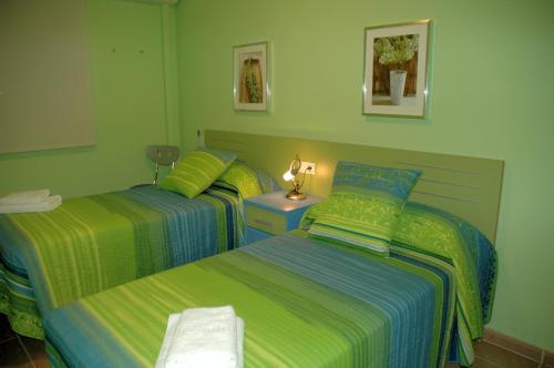 two beds in a room with green walls at Casa Nuri de Rei La Pobla Tornesa in Puebla Tornesa