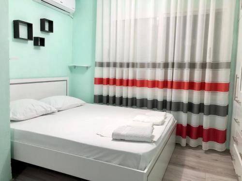 um pequeno quarto com uma cama e uma cortina em Superb studio apartment near to the city center em Tirana