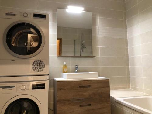 a bathroom with a sink and a washing machine at *NEW* Bellevue D’Oz Ski In Ski Out Luxury Apartment (8-10 Guests) in Oz