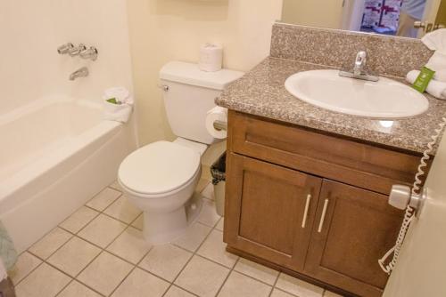 a bathroom with a toilet and a sink at California Suites Hotel in San Diego