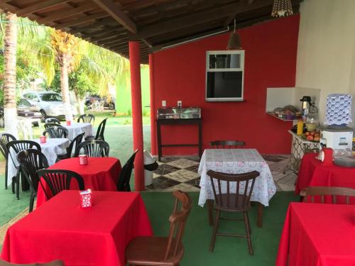 a restaurant with red tables and chairs and a red wall at Pousada Res. Belmont in Pirangi do Norte