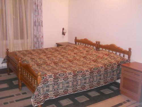 a bedroom with a large bed with a wooden frame at Dili Villa in Dilijan