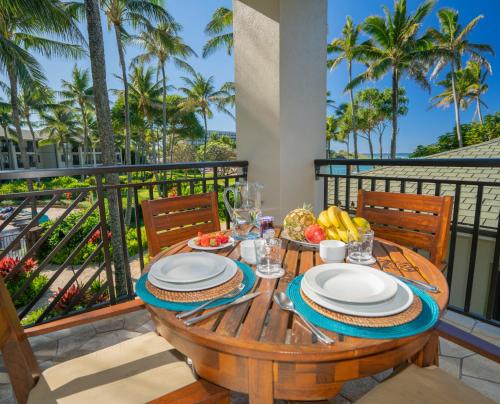 a table with plates of food on a balcony with palm trees at Stunning Luxurious Ocean Villa with Ocean Views From All bedrooms. in Kahuku