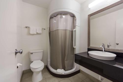 uma casa de banho com um chuveiro, um WC e um lavatório. em Motel 6-Meridian, MS em Meridian