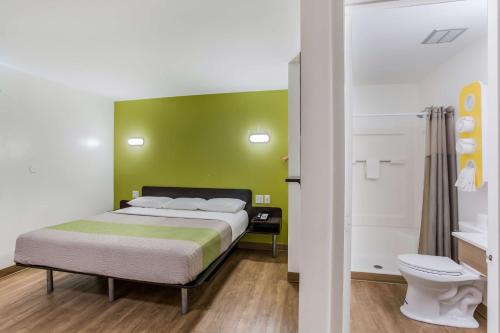 - une chambre avec un lit et un mur vert dans l'établissement Motel 6-Jacksonville, FL - South, à Jacksonville