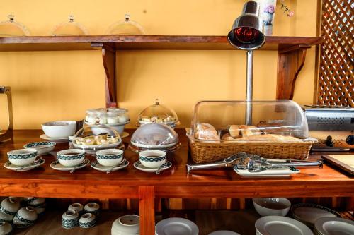 a table with a bunch of cups and dishes on it at Vida Loca Sunset Beach Resort in Phu Quoc