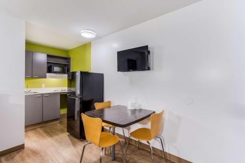a kitchen and dining room with a table and chairs at Studio 6 Extended Stay - Jacksonville, FL - South in Sunbeam