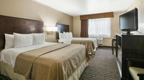 a hotel room with two beds and a flat screen tv at Best Western San Marcos in San Marcos