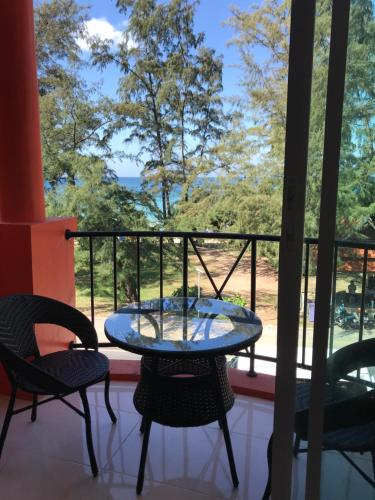 a table and chairs on a balcony with a view at Sunny Beach View Guesthouse in Ka Rorn