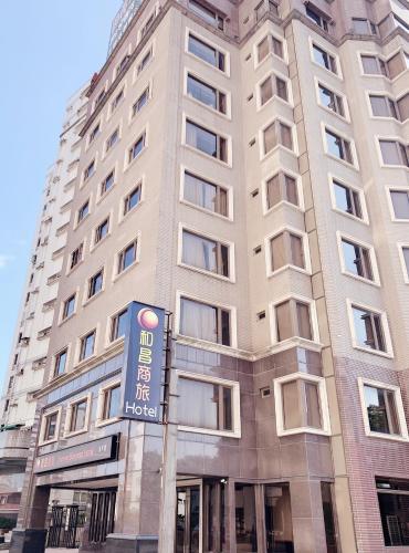 wysoki budynek z znakiem przed nim w obiekcie Sunrise Business Hotel - Tamsui w mieście Tamsui