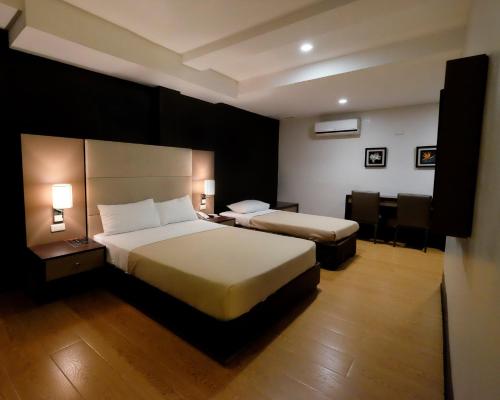 una habitación de hotel con 2 camas y una silla en 3G Garden Hotel en General Santos