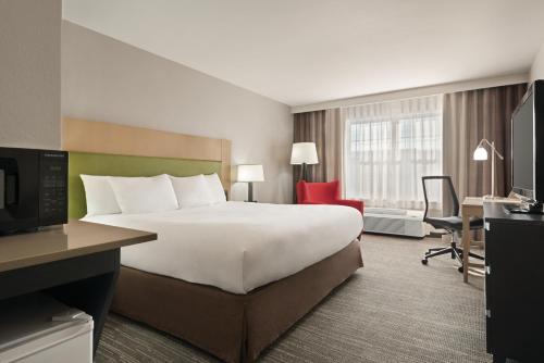 a hotel room with a large bed and a desk at Country Inn & Suites by Radisson, Dubuque, IA in Dubuque