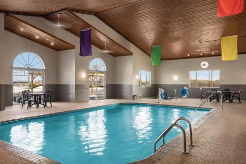 - une piscine avec des tables et des chaises dans un bâtiment dans l'établissement Country Inn & Suites by Radisson, Dubuque, IA, à Dubuque