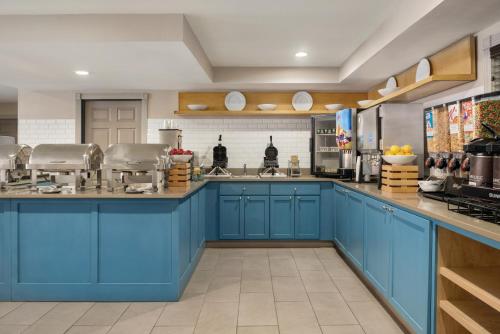 a large kitchen with blue cabinets at Country Inn & Suites by Radisson, Dubuque, IA in Dubuque