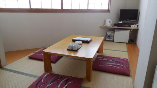 a living room with a table and a coffee table at Kuretake Inn Gotemba Inter Gold Cabin in Gotemba