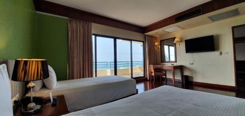 een hotelkamer met 2 bedden en uitzicht op de oceaan bij Garden Sea View Resort in Noord Pattaya