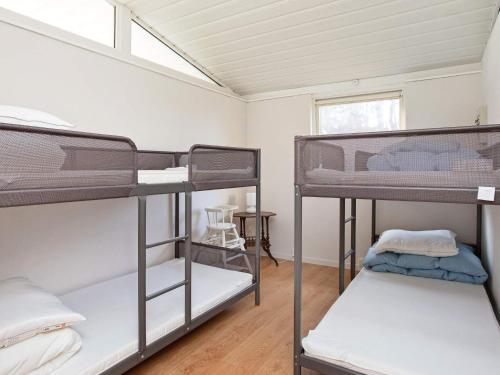 a room with three bunk beds and a window at Holiday home Sjællands Odde VIII in Tjørneholm