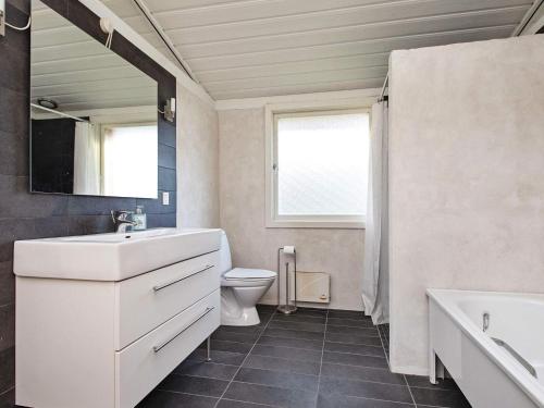 a bathroom with a sink and a toilet and a mirror at Holiday home Sjællands Odde VIII in Tjørneholm