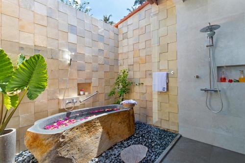 a bathroom with a stone tub and a shower at Villa Ronggo Mayang at Balian beach in Antasari