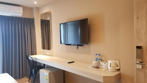 a hotel room with a counter with a television on the wall at The Phoenix Hotel Bangkok - Suvarnabhumi Airport in Lat Krabang