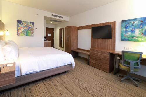 a hotel room with a bed and a desk and a television at Holiday Inn Express & Suites - Ensenada Centro by IHG in Ensenada