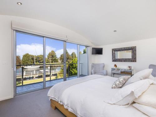 a bedroom with a large bed and a large window at The Quarterdeck in Port Fairy