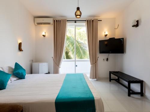 1 dormitorio con 1 cama grande y TV en Royal Mount Hotel en Mount Lavinia