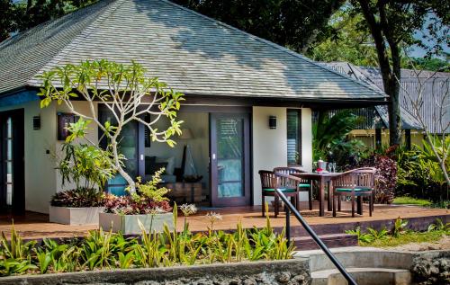 a house with a porch with a table and chairs at Warwick Le Lagon Resort & Spa, Vanuatu in Port Vila